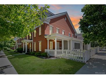 Charming two-story brick home with manicured lawn and classic white picket fence detail at 11791 Bradburn Blvd, Westminster, CO 80031