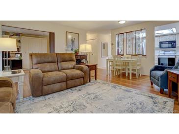 Inviting living room features comfortable seating and a dining area with unique decorative glass paneling at 13631 E Marina Dr # 109, Aurora, CO 80014