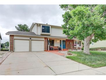 Charming two-story home with a two-car garage, mature landscaping, and a welcoming front porch at 10137 W Berry Dr, Littleton, CO 80127