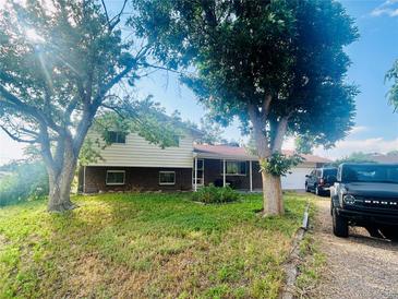 Charming two-story home with brick accents, mature trees, and a welcoming front porch at 2281 Fairplay St, Aurora, CO 80011