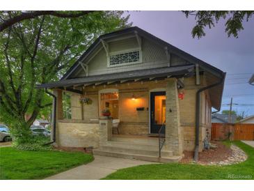 Charming brick home with a covered front porch and green lawn at 1172 Harrison St, Denver, CO 80206