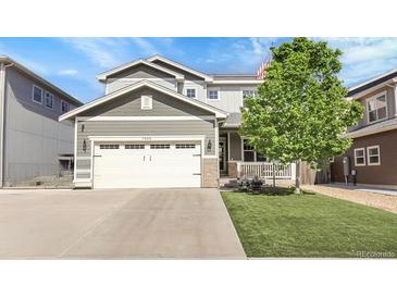 Charming two-story home with a well-manicured lawn, large tree, and attached two-car garage at 7888 Tejon St, Denver, CO 80221