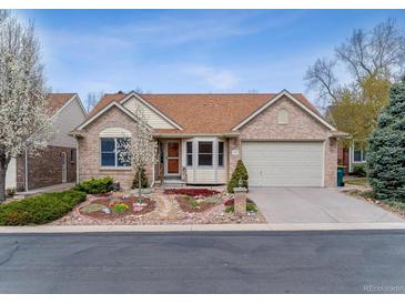 Charming brick home featuring a well-manicured front yard and two-car garage at 1185 S Kramer Ct, Aurora, CO 80012