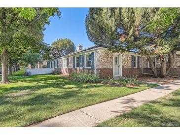 Charming brick home featuring a well-maintained lawn and a traditional design with blue shutters at 1279 Leyden St, Denver, CO 80220