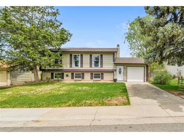 Charming two-story home with a well-manicured lawn, attached garage, and inviting curb appeal at 16025 E Warren Pl, Aurora, CO 80013
