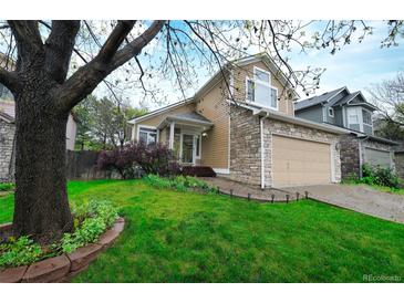 Charming two-story home features a stone and vinyl facade, well-manicured lawn, and an attached two-car garage at 3565 W 112Th Cir, Westminster, CO 80031