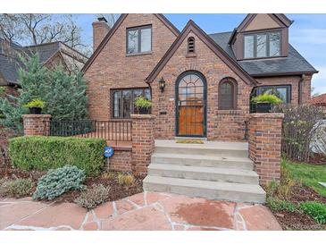 Charming brick home with a beautiful arched front door and well-maintained landscaping at 371 Birch St, Denver, CO 80220