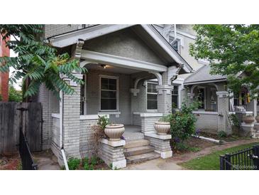 Charming brick front porch with decorative pillars and ornate flower pots, offering a cozy and inviting entryway at 1266 N Pearl St, Denver, CO 80203