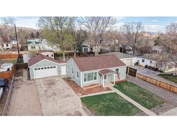 Charming single-Gathering home with a detached garage and green lawn at 415 S Parfet St, Lakewood, CO 80226