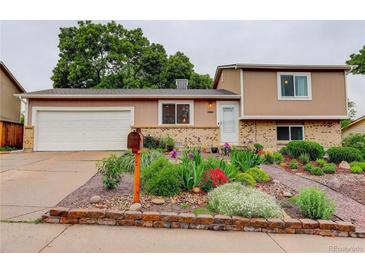 Charming home with a well-maintained front yard featuring colorful flowers and lush greenery at 10527 Pierson Cir, Westminster, CO 80021