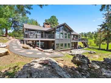 Modern two-story home with large windows and balconies overlooking a beautifully landscaped yard at 1555 Genesee Ridge Rd, Golden, CO 80401
