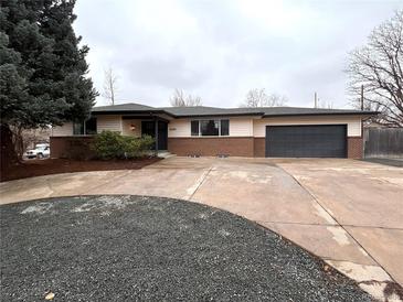 Ranch style home with a large driveway and two-car garage, complimented with fresh landscaping at 6586 W Leawood Dr, Littleton, CO 80123