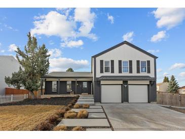 Charming two-story home featuring a three-car garage and modern, painted brick and siding exterior at 16402 E Tennessee Ave, Aurora, CO 80017