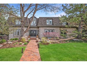Charming two-story home with beautiful landscaping and a brick walkway leading to the front door at 5442 S Dayton Ct, Greenwood Village, CO 80111