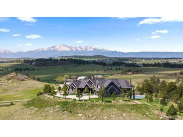 Expansive mountain home with lush green surroundings and a large driveway at 15295 E Cherry Creek S Rd, Larkspur, CO 80118
