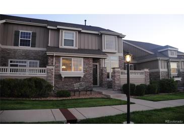 Charming townhome featuring stone accents, covered entry, and well-maintained landscaping at 4746 Raven Run, Broomfield, CO 80023