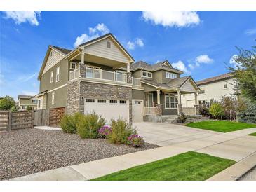 Beautiful two-story home with stone accents, a spacious balcony, and a well-manicured lawn at 16060 Fairway, Commerce City, CO 80022
