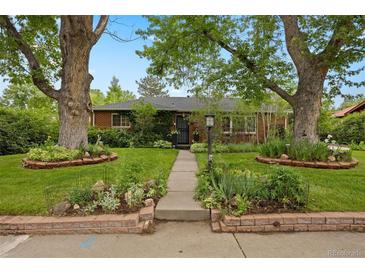 Charming home featuring a landscaped front yard with mature trees and a welcoming walkway at 4580 S Huron St, Englewood, CO 80110