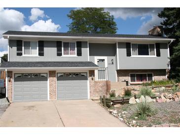 Charming home with a two-car garage, gray siding and landscaped front yard at 1008 Park View Ct, Castle Rock, CO 80104