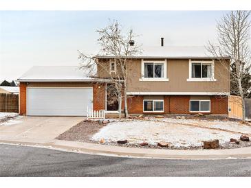 Charming two-story home with brick accents, attached garage, and a well-maintained front yard at 9240 W Wagon Trail Dr, Littleton, CO 80123