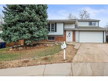 Charming two-story home featuring a well-maintained front yard, brick accents, and an attached two-car garage at 16325 E Alabama Dr, Aurora, CO 80017