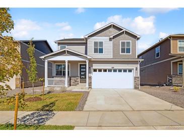 Two-story house with gray siding, white garage door, and a front porch at 6530 13Th St, Frederick, CO 80530