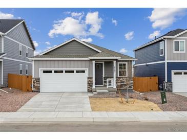 Charming single-story home with gray siding, stone accents, and a two-car garage at 6500 13Th St, Frederick, CO 80530