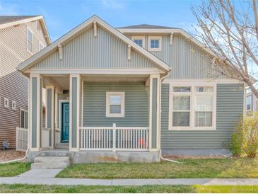 Charming home featuring a covered front porch, two stories, a manicured lawn, and stylish curb appeal at 9626 E 105Th Pl, Commerce City, CO 80640