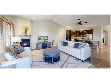 Cozy living room with fireplace, plush seating, and open floor plan to the kitchen at 6931 Buckskin Dr, Littleton, CO 80125