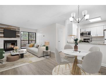 Bright, open-concept living and dining area with a fireplace and access to a balcony at 14720 E Kentucky Dr # 622, Aurora, CO 80012