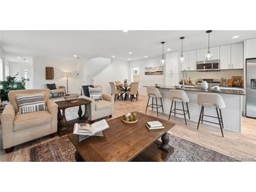 Open-concept layout connecting the living room, kitchen, and dining area with lots of natural light at 5242 Columbine Ln, Denver, CO 80221