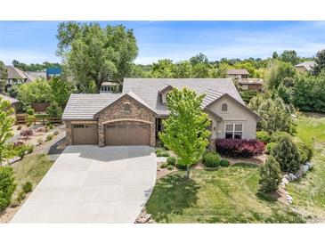 Beautiful home featuring stone accents, a three-car garage, and a well-maintained lawn at 3380 Quail Ct, Wheat Ridge, CO 80033