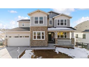 Two-story house with stone facade and attached garage at 8773 Yellowcress St, Littleton, CO 80125