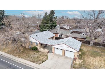 Aerial view of a brick home with a white roof and attached two-car garage on a tree-lined street at 2300 Joliet St, Aurora, CO 80010