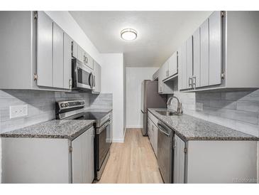 Modern kitchen featuring stainless steel appliances, grey cabinets, and granite countertops at 16259 W 10Th Ave # K-3, Golden, CO 80401