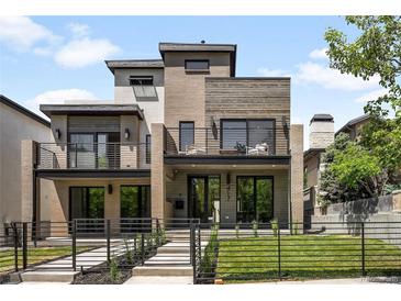 Modern, two-story home showcasing a unique facade with a mix of brick and wooden finishes and small front yard at 417 N Madison St, Denver, CO 80206