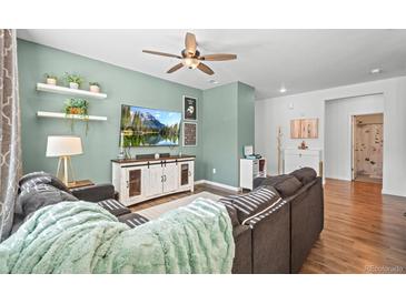 Comfortable living room with a ceiling fan, floating shelves, entertainment center and modern decor at 4604 Copeland Cir # 101, Highlands Ranch, CO 80126