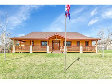Ranch style home with covered porch, stone accents, and mature lawn at 5365 Eldridge St, Arvada, CO 80002