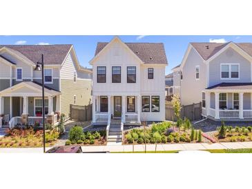 Charming two-story home with white siding, a cozy front porch, and manicured landscaping at 175 Westerly Blvd, Erie, CO 80516