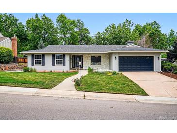 Charming home featuring a well-manicured lawn, painted brick and stone details and an attached two car garage at 6874 S Detroit Cir, Centennial, CO 80122