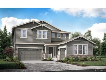 Inviting two-story home featuring a two-car garage, stone accents, and a covered entry at 4599 Windmill Dr, Brighton, CO 80601