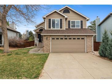 Inviting two-story home featuring a two-car garage, classic architecture, and well-manicured lawn at 6425 Nassau Ct, Highlands Ranch, CO 80130