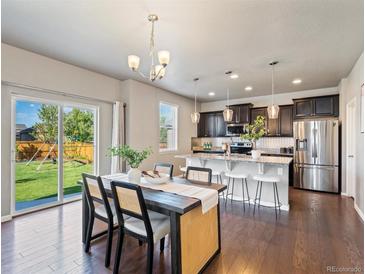 Dining area with table, chairs, pendant light, and a sliding glass door to the backyard at 1181 W 170 Th Ave, Broomfield, CO 80023