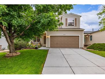 Charming two-story home featuring a manicured lawn, large tree and a spacious two-car garage at 2905 S Deframe Way, Lakewood, CO 80228