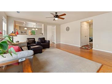 Spacious living room features hardwood floors, a ceiling fan, and an open floor plan at 5526 Lewiston St, Denver, CO 80239