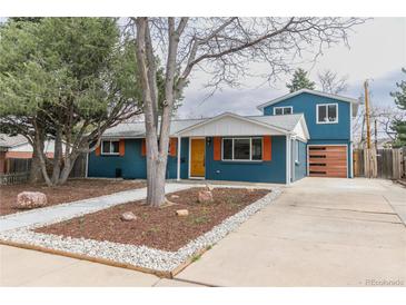 Charming two-story home with blue siding, orange shutters, manicured yard, and inviting curb appeal at 1120 Hartford Dr, Boulder, CO 80305