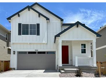Charming two-story home with a red door, gray garage door, and a well-manicured lawn at 9286 Telluride Ct, Commerce City, CO 80022
