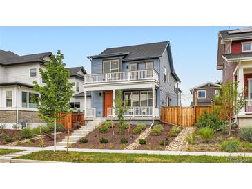 Charming two-story home boasts a welcoming porch, balcony, and well-manicured front yard at 9769 E 62Nd Dr, Denver, CO 80238