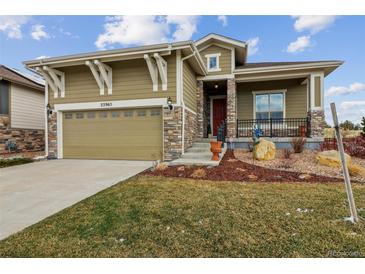 Charming home with stone accents, an attached two-car garage, and a beautifully landscaped front yard at 22965 E Bailey Cir, Aurora, CO 80016