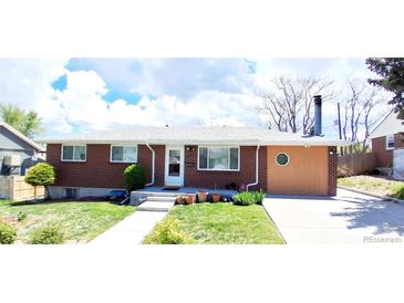 Charming brick home featuring a well-maintained front yard and driveway at 8338 Charles Way, Denver, CO 80221